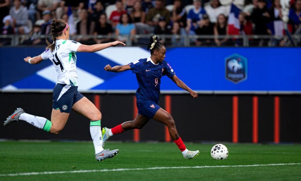 SPP1338586 womensfootballmagazinecom Womens soccer action a player in dark blue dribbles toward the ball as a defender in white pursues